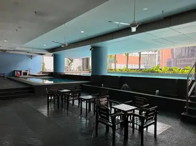 a dining room with tables and chairs in a building at Cozy home in city center with free parking - 1A in Kuala Lumpur