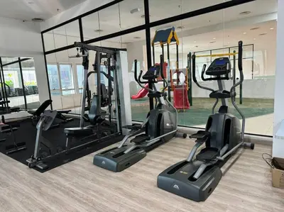 a gym with three treadmills and elliptical machines at Cozy home in city center with free parking - 1A in Kuala Lumpur