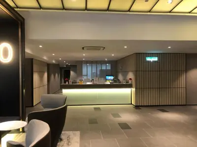 a lobby with chairs and a bar in a building at Ceylonz Suites By Staybliss in Kuala Lumpur