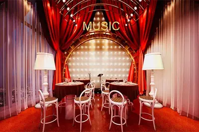 a restaurant with tables and chairs in a room with red curtains at Scarletz suites klcc Bukit Bintang by lulu in Kuala Lumpur