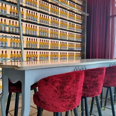 a bar with red chairs and bottles of champagne at Scarletz suites klcc Bukit Bintang by lulu in Kuala Lumpur