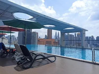 a swimming pool with chairs and umbrellas on a building at D'Majestic Place in Kuala Lumpur