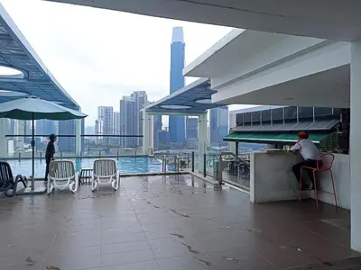 a man sitting at a bar on the top of a building at D'Majestic Place, 1 King or 2 Super Single beds in Kuala Lumpur