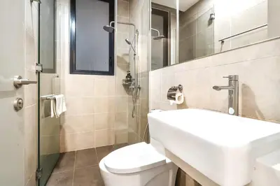 a bathroom with a sink and a toilet and a mirror at KL Gateway Residences in Kuala Lumpur