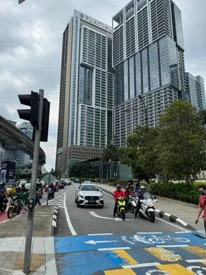 a group of people riding motorcycles on a street with buildings at The Platinum Kuala Lumpur KLCC By Garden Suites in Kuala Lumpur