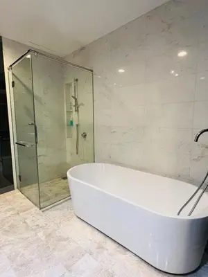 a white tub in a bathroom with a glass shower at The Platinum Kuala Lumpur KLCC By Garden Suites in Kuala Lumpur