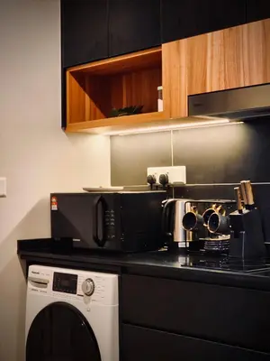 a kitchen with a microwave and a washing machine at Axon Suite Premium KL in Kuala Lumpur
