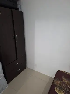 a bedroom with black cabinets and a white wall at vista sentul residence share apartment with host in Kuala Lumpur
