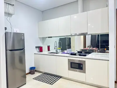 a kitchen with white cabinets and a stainless steel refrigerator at 2bedroom SOHO SUITE KLCC View by Homeizing in Kuala Lumpur