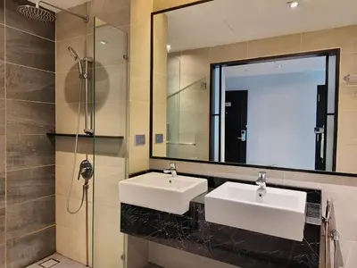 a bathroom with two sinks and a large mirror at Suites at Maison 101,Heart Of KL City in Kuala Lumpur