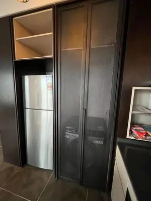 a black refrigerator and freezer in a kitchen at Borderless Swimming Pool - Invincible Twin Towers View - Free WiFi in Kampong Gombak Utara