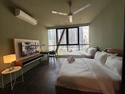 a hotel room with two beds and a flat screen tv at Borderless Swimming Pool - Invincible Twin Towers View - Free WiFi in Kampong Gombak Utara