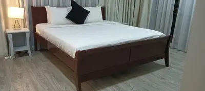 a bed with white sheets and black pillows in a room at KL Apartment At Berjaya Times Square in Kuala Lumpur