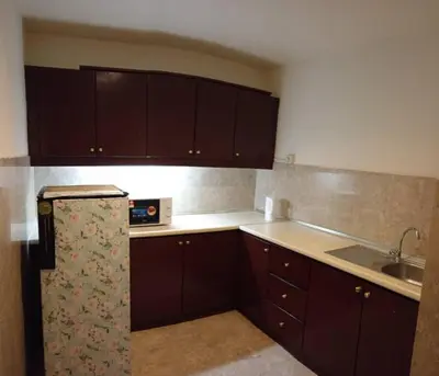 a kitchen with brown cabinets and a sink at KL Apartment At Berjaya Times Square in Kuala Lumpur