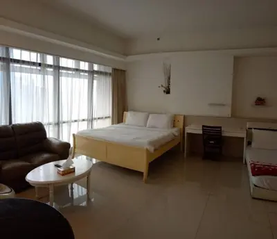 a bedroom with a bed and a couch and a table at KL Apartment At Berjaya Times Square in Kuala Lumpur