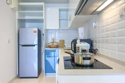 a kitchen with a stove and a refrigerator at Continew TRX Corner House +2 Balconies +2 Rooms in Kuala Lumpur