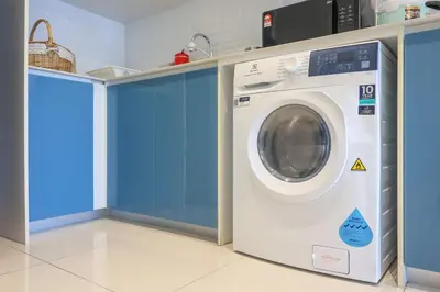 a washing machine in a room with blue walls at Continew TRX Corner House +2 Balconies +2 Rooms in Kuala Lumpur