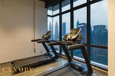 two exercise bikes in a gym with a view of the city at The Manor Serviced Residence by Canopy Lives in Kuala Lumpur