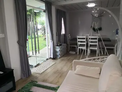 a living room with a white couch and a dining room at Titiwangsa Cabin Retreats by uBook in Kuala Lumpur