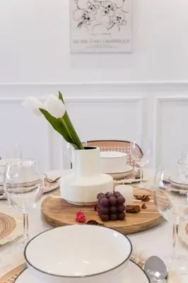 a table with plates and glasses and a vase with a flower at M Vertica KL City Tower C By Feel Home in Kuala Lumpur