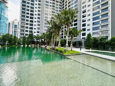 a large pool of water with palm trees and buildings at Agile Bukit Bintang Suites TRX in Kuala Lumpur