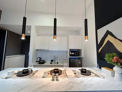 a kitchen with a table with plates and wine glasses at Chambers Residence by Manhattan Group in Kuala Lumpur