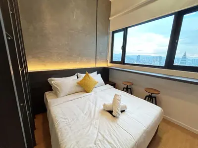 a bedroom with a bed with white sheets and a window at Chambers Residence by Manhattan Group in Kuala Lumpur