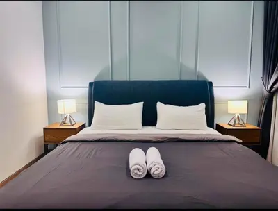 a pair of white shoes sitting on a bed at Luxurious Home Smart service Lucentia residence in Kuala Lumpur