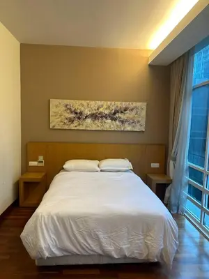 a bedroom with a white bed and a painting on the wall at KLCC Room in Kuala Lumpur