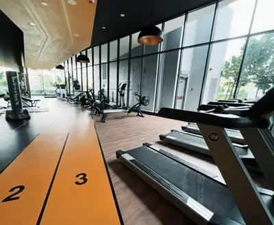 a gym with rows of treadmills in a room with windows at Neu suites 001 cozy studio klcc in Kuala Lumpur