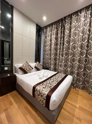 a bedroom with a large bed and a curtain at The Dorsett Residence Service Suite KL in Kuala Lumpur