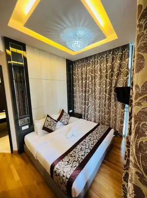 a bedroom with a large bed with a ceiling at The Dorsett Residence Service Suite KL in Kuala Lumpur