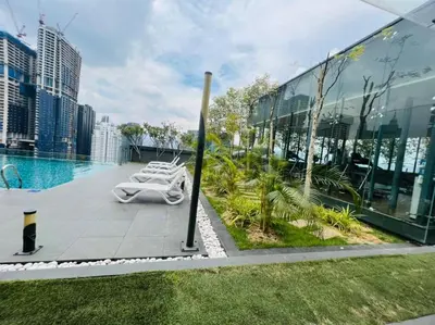 a pool with lounge chairs on the side of a building at The Dorsett Residence Service Suite KL in Kuala Lumpur