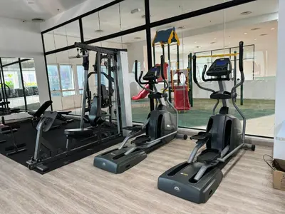 a gym with several treadmills and elliptical machines at Cozy home in city center with free parking -1D in Kuala Lumpur