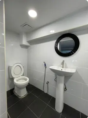 a bathroom with a toilet and a sink and a mirror at Cozy home in city center with free parking -1D in Kuala Lumpur