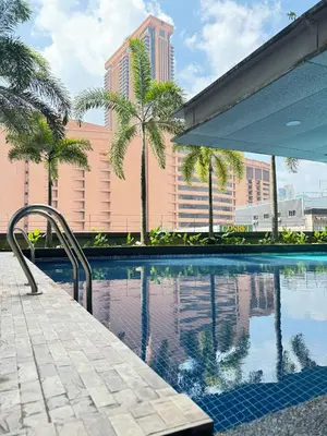 a swimming pool with palm trees and a building at Cozy home in city center with free parking -1D in Kuala Lumpur