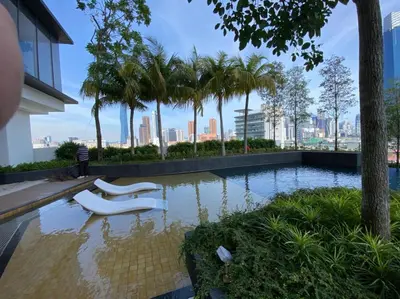a swimming pool with two white chairs in a building at CONTINEW Residence - TRX KL in Kuala Lumpur