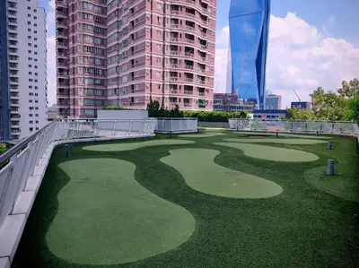 a golf course in the middle of a city with tall buildings at Robertson to be opened in Kuala Lumpur