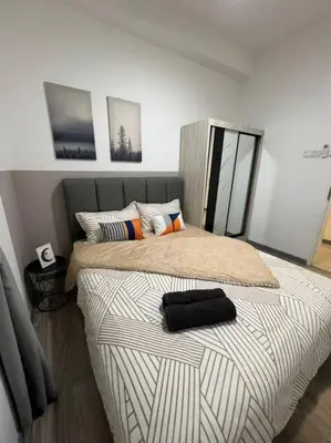 a bedroom with a bed with a black pillow on it at The City Edge United Point in Kuala Lumpur