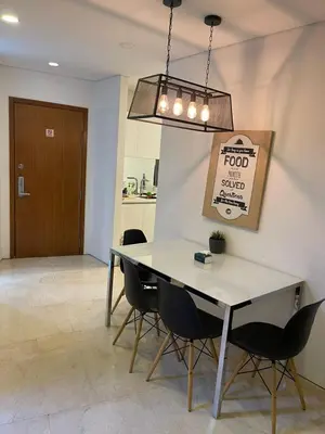 a dining room with a table and chairs and a sign at Vortex Family suites Apartment in Kuala Lumpur