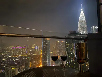 two wine glasses on a table with a view of a city at Luxury Penthouse KLCC & KL TOWER View in Kuala Lumpur in Kuala Lumpur