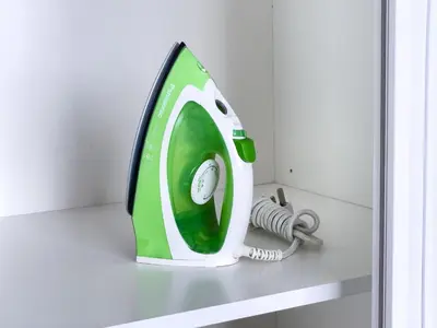 a green and white iron sitting on a shelf at Luxury Penthouse KLCC & KL TOWER View in Kuala Lumpur in Kuala Lumpur