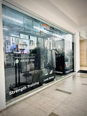 a store window with a advertisement for strength training at Damas Hotel,Suites and Residence at Plaza Damas 3 by Over The Moon in Kuala Lumpur