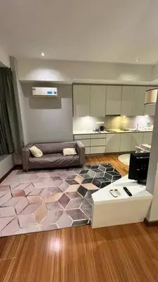 a living room with a couch and a kitchen at KLCC Apartment in Kuala Lumpur