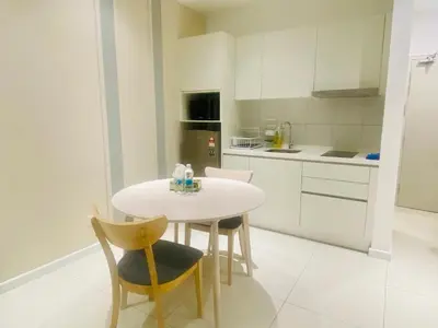 a white kitchen with a white table and chairs at Chambers Luxury Suites By Zaff in Kuala Lumpur