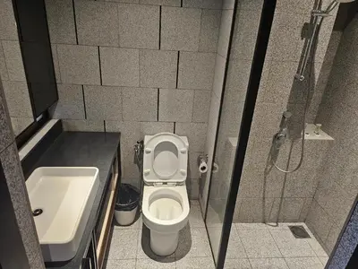 a bathroom with a shower and a toilet and a sink at Scarletz Suites KLCC by Luxe Suites in Kuala Lumpur