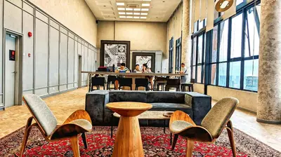 a lobby with chairs and a table in a building at Scarletz Suites KLCC by Luxe Suites in Kuala Lumpur