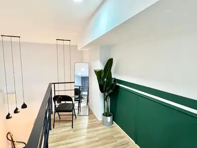 a hallway with a green wall and a dining room at Arte Cheras Kuala Lumpur in Kuala Lumpur
