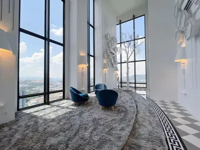 a room with two blue chairs and large windows at Arte Cheras Kuala Lumpur in Kuala Lumpur