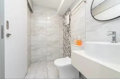 a white bathroom with a toilet and a mirror at Arte Cheras Kuala Lumpur in Kuala Lumpur